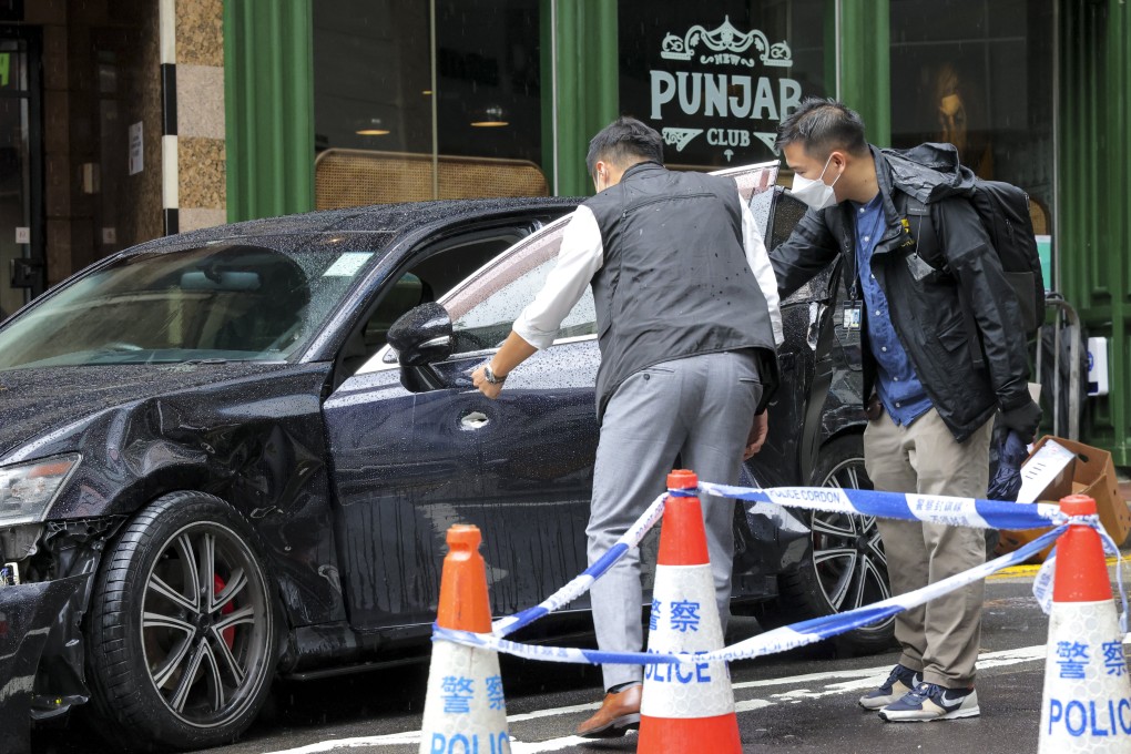 Police inspect what appears to be a bullet hole on one side of a damaged car. Photo: Jelly Tse