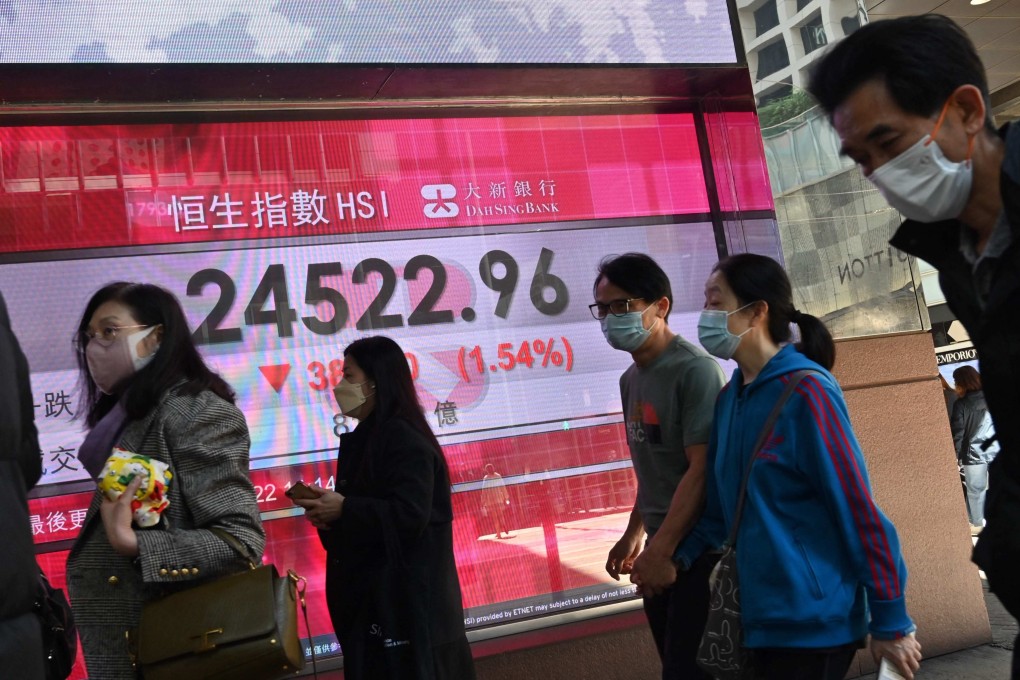 People walk past an elecgtronic board showing the Hang Seng Index level on February 14, 2022. Photo: AFP