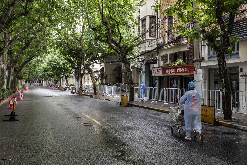 A worker in personal protective equipment pushes a cart of lunch deliveries for residents near a neighborhood placed under lockdown in Shanghai. Photo: Bloomberg