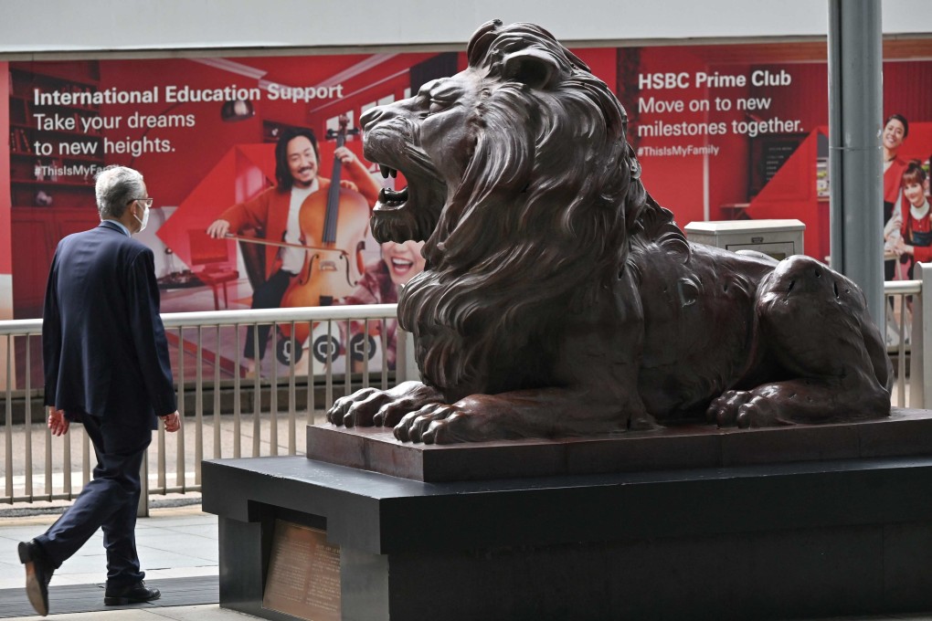 A pedestrian walks past the lions in front of HSBC’s main building in Cental. Photo: AFP
