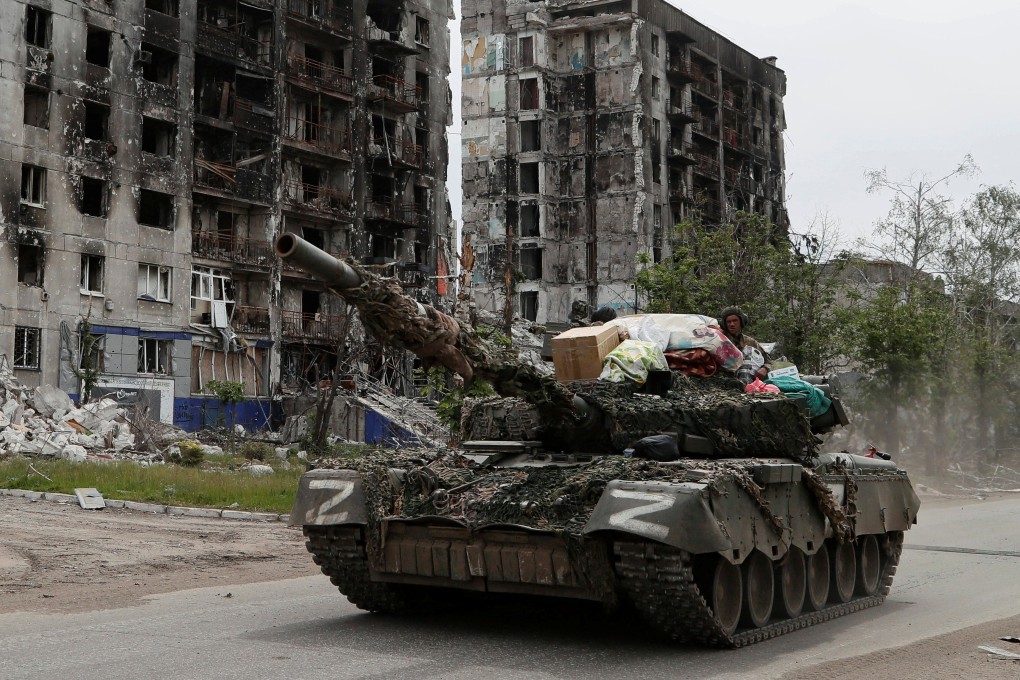 Service members of pro-Russian troops drive a tank along a street past a destroyed residential building in the town of Popasna in the Luhansk region on May 26. Photo: Reuters