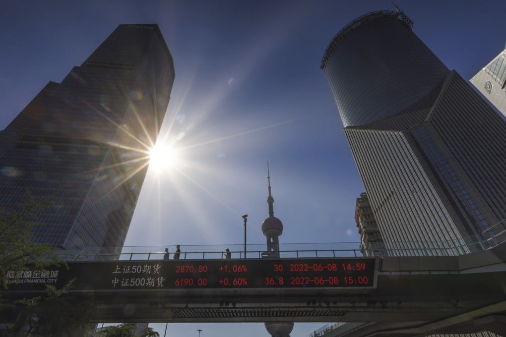 People walk on pedestrian bridge showing stock exchange data in Lujiazui in Shanghaii on June 8. Photo: EPA-EFE