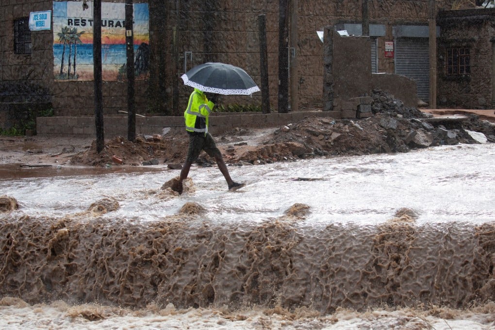 A man crosses a flooded bridge in kwaNdengezi near Durban, South Africa on May 22. Photo: Reuters