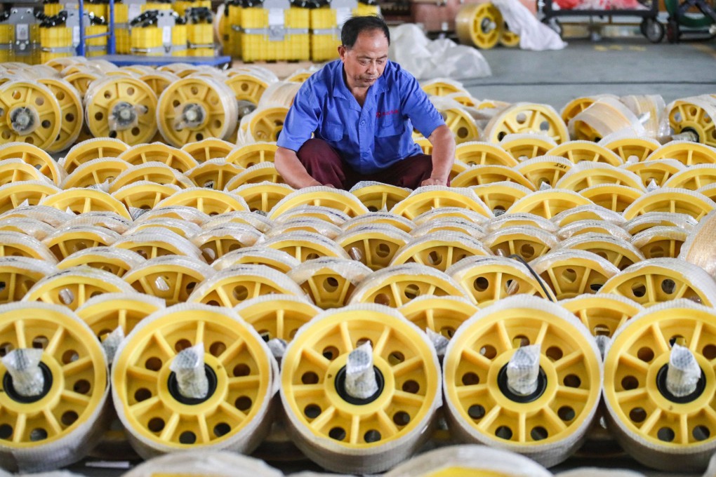 A worker adjusts the packaging on lift rollers at a factory in Huaian, in China’s eastern Jiangsu province, on June 9. Photo: AFP
