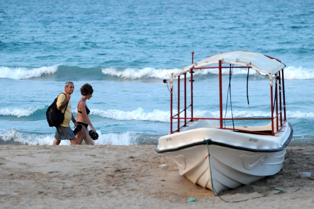 Tourists walk along a beach in eastern Sri Lanka. Photo: AFP
