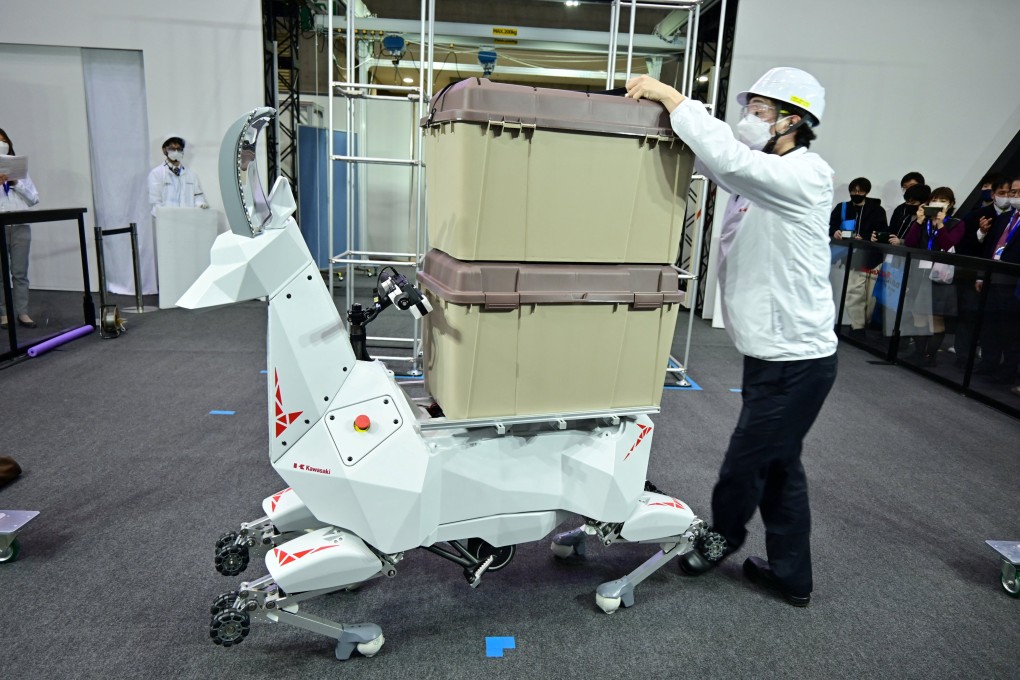 An employee of Japan’s Kawasaki Heavy Industries demonstrates a goat-like robot that can carry goods, in Tokyo, on March 9. By partnering with Microsoft for its industrial metaverse, the company plans to create a digital twin, or virtual replica, of its factories. Photo: Handout from Kawasaki Heavy Industries via Reuters