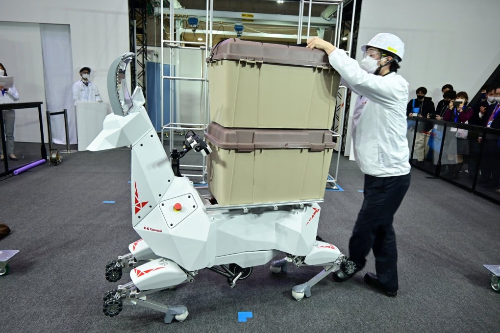 An employee of Japan’s Kawasaki Heavy Industries demonstrates a goat-like robot that can carry goods, in Tokyo, on March 9. By partnering with Microsoft for its industrial metaverse, the company plans to create a digital twin, or virtual replica, of its factories. Photo: Handout from Kawasaki Heavy Industries via Reuters