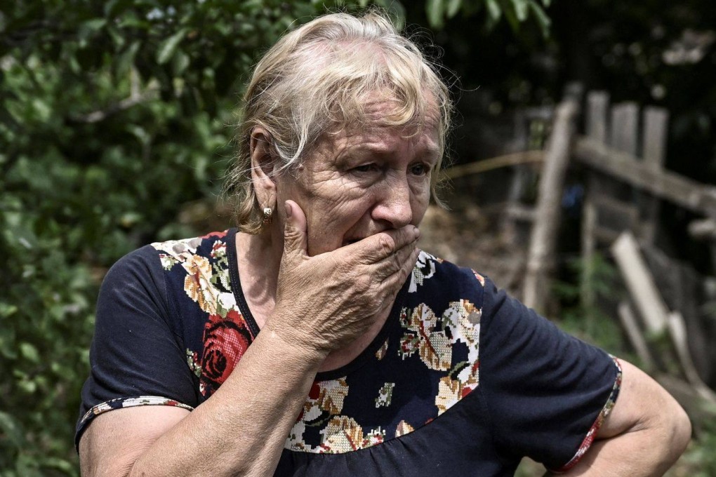 Yevgeniya Panicheva stands in the yard of a house where two neighbours were killed during shelling in the city of Lysychansk. Photo: AFP