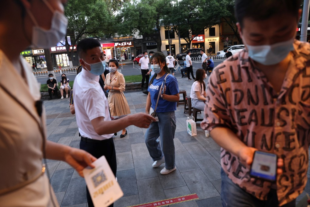Customers show their health codes before entering a restaurant on June 6 as dine-in services resume in Beijing. The zero-Covid system requiring people to report their every move is a big step beyond digital surveillance. Photo: Reuters