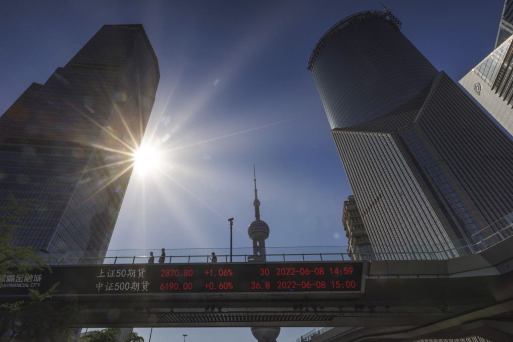 People walk on pedestrian bridge showing stock exchange data in Shanghai on June 8, 2022. Photo:. EPA-EFE