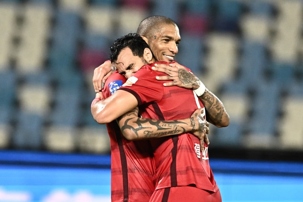 Henrique Dourado (back) hugs Henan teammate Fernando Karanga after their 3-0 win over Guangzhou City. Photo: Xinhua