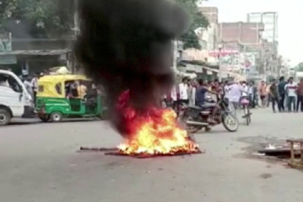 Demonstrators surround burning tyres on a street as they protest against “Agnipath scheme” for recruiting personnel for armed forces, in Jehanabad, Bihar, India on Thursday. Photo: ANI/Handout via Reuters