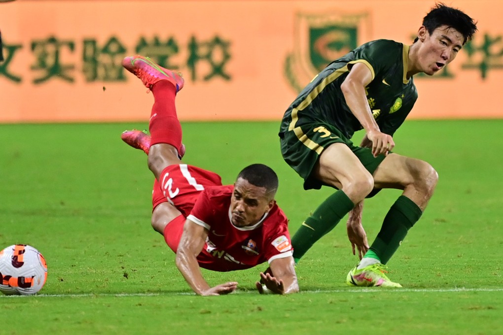 Rodrigo Henrique (left) of Meizhou Hakka falls during their match against Beijing Guoan. Photo: Xinhua