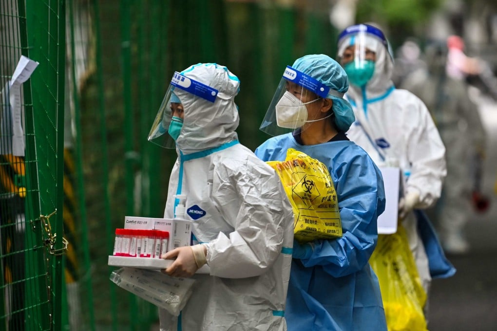 Health workers carry swab samples taken from locked down residents in Shanghai. Photo: AFP