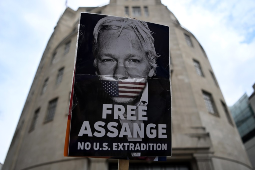 A protester holds up a placard demonstrating against Julian Assange’s extradition to the US in central London on Saturday. Photo: EPA-EFE