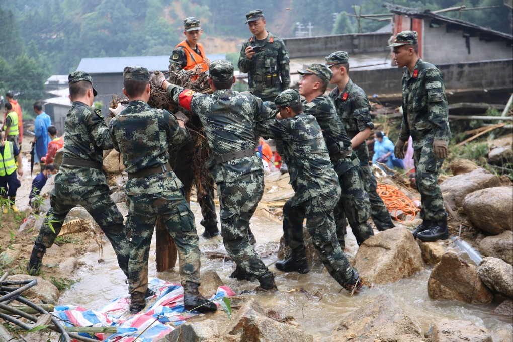 Rescue workers help at the site where a building collapsed following flooding in China’s southern Guangxi region on Saturday. Photo: cnsphoto