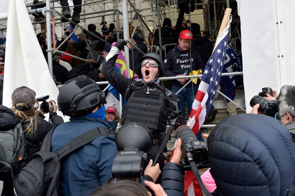 A man calls on people to raid the building as Trump supporters clash with police and security forces as they try to storm the US Capitol on January 6, 2021. Photo: AFP