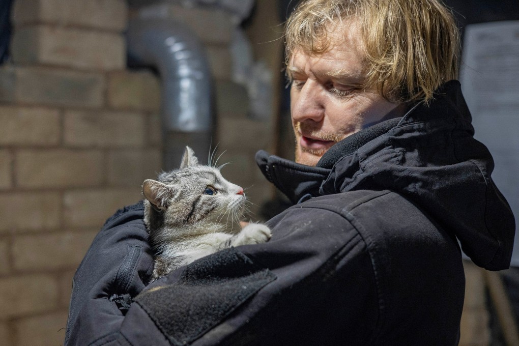 Ukrainian photographer Maksim Levin holds a cat near the line of separation from Russian-backed separatists in Luhansk region in January. Photo: Reuters