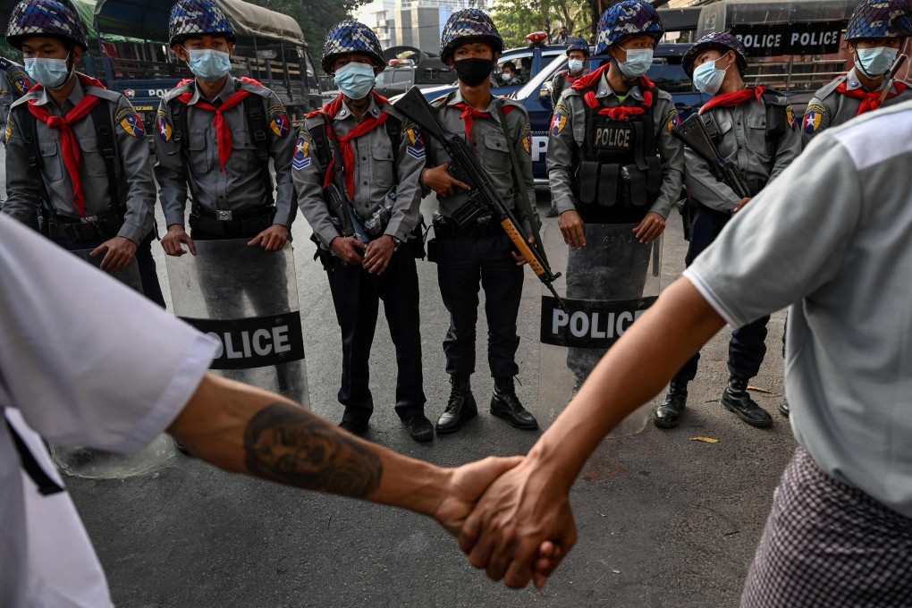 Anti-junta protesters hold hands in front of the police in Yangon, Myanmar, in February 2021. Photo: AFP