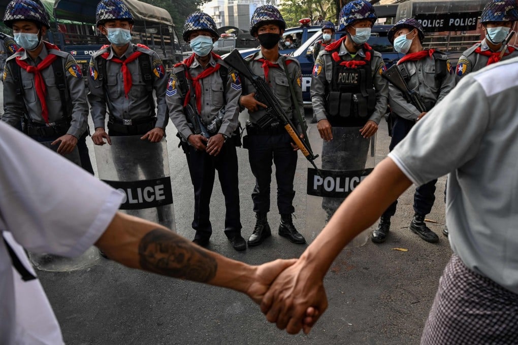 Anti-junta protesters hold hands in front of the police in Yangon, Myanmar, in February 2021. Photo: AFP