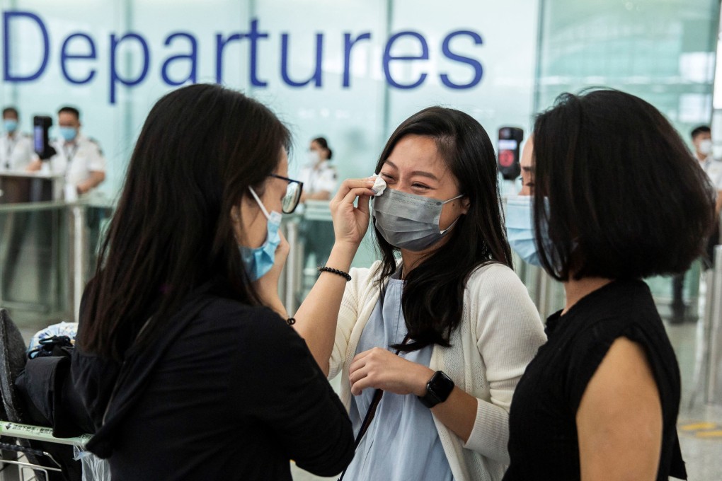 Friends cry at the departure gates of Hong Kong International Airport before one of them emigrates to Britain on July 19, 2021. Photo: AFP