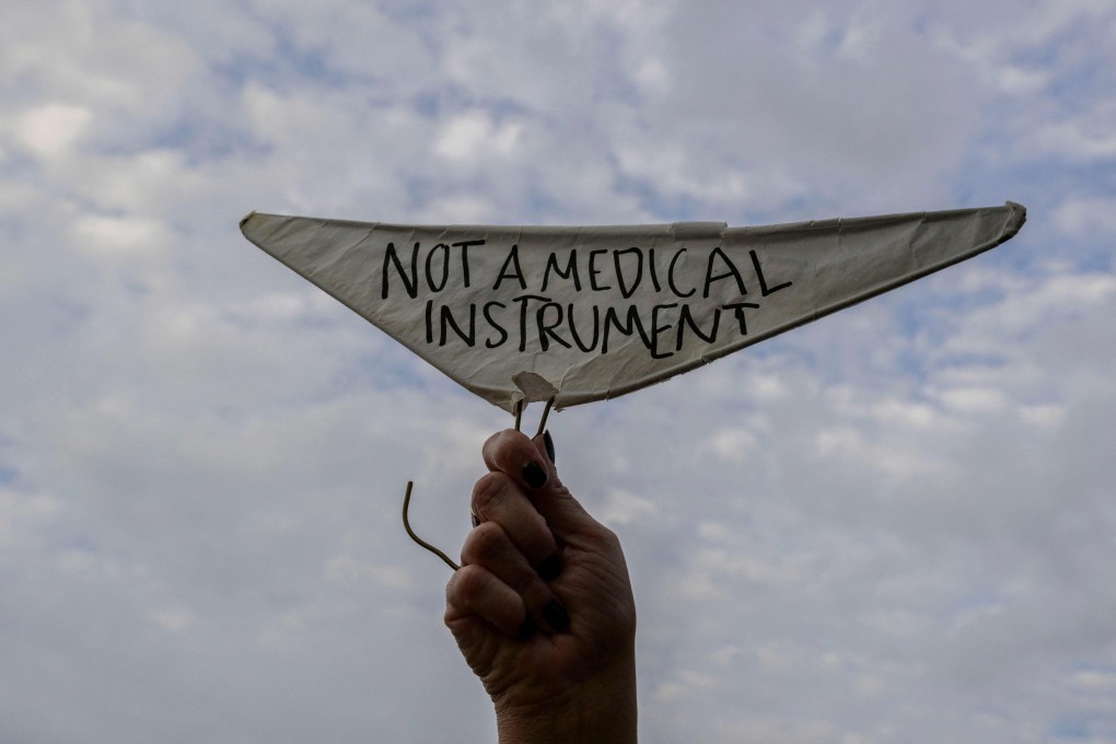 A hand holds a metal coat hanger, a symbol of the reproductive rights movement, with the words “Not a Medical Instrument” as abortion rights activists protest in St. Louis, Missouri, on Friday. Photo: AFP
