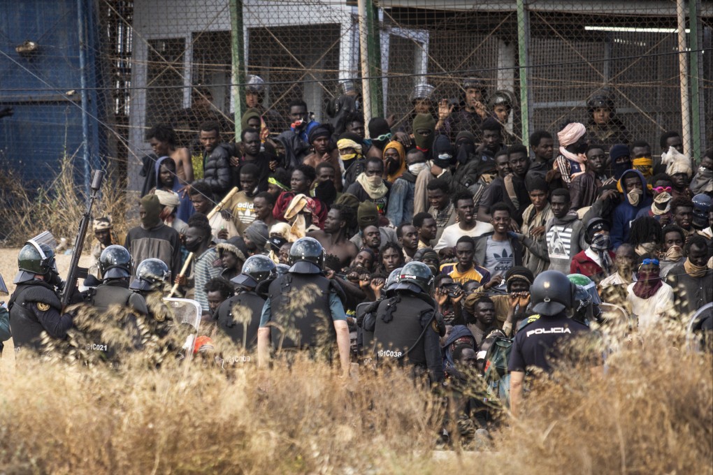 Riot police cordon off the area on Friday after migrants arrive on Spanish soil having crossed fences separating the Spanish enclave of Melilla from Morocco. Photo: AP