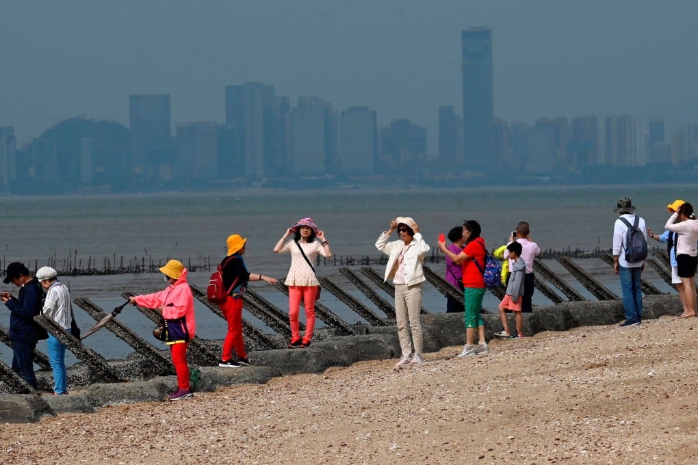 Tourists in October 2020 stand alongside anti-landing spikes on one of the Quemoy islets, with Xiamen on mainland China in the background. Taipei Mayor Ko Wen-je’s proposal to build a Xiamen-Quemoy bridge has drawn sharp criticism from other Taiwan politicians. Photo: AFP