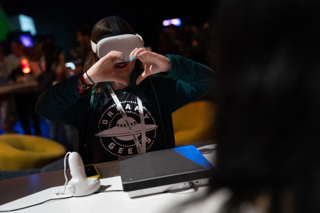 An exhibitor makes a heart gesture while wearing a Meta Oculus Quest 2 virtual reality headset at the NFT LA conference in Los Angeles on March 30, 2022.  Photo: Bloomberg