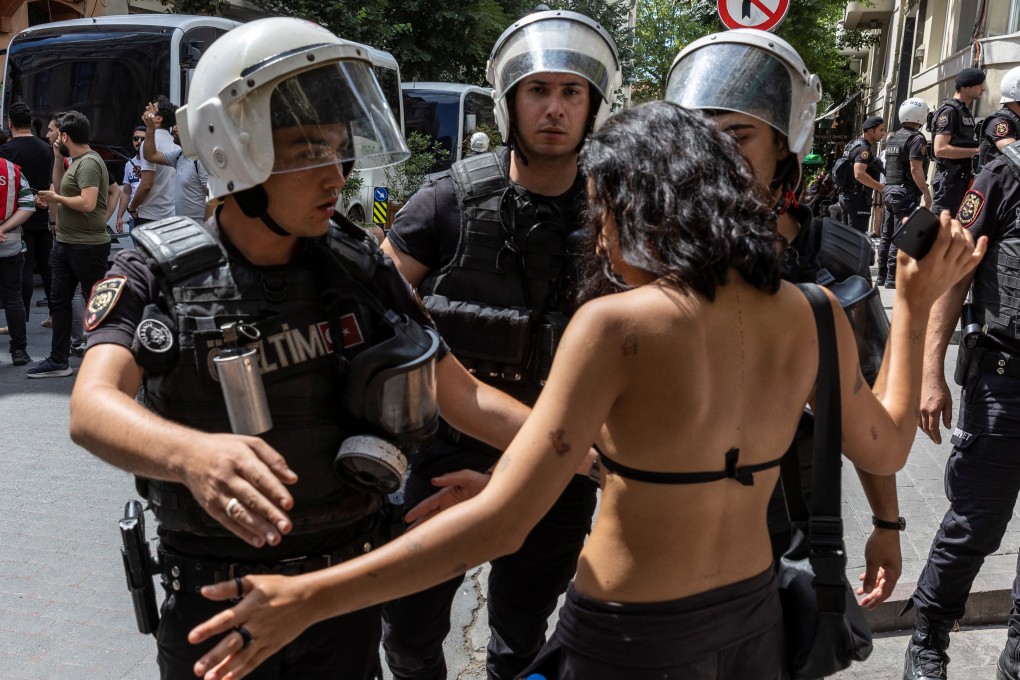 Police officers prevent an activist from marching in a pride parade, which was banned by local authorities, in central Istanbul, Turkey on Sunday. Photo: Reuters
