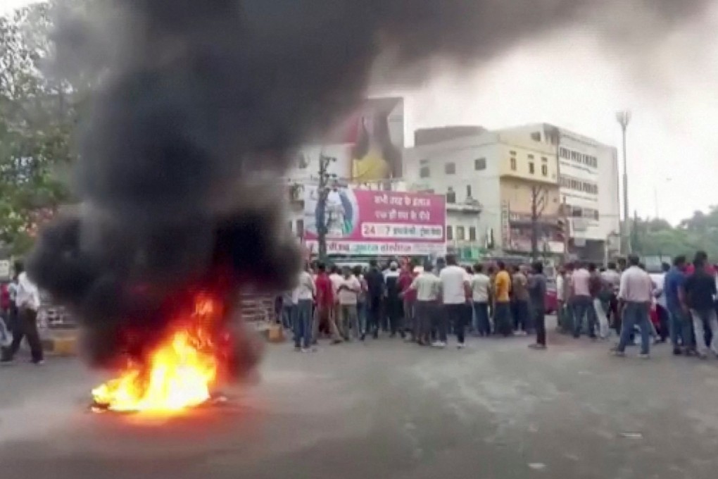 Smoke rises from a fire as people gather on a road amid rising tensions after the killing of a Hindu man in Udaipur, India’s Rajasthan state, on Tuesday. Photo: Asian News International Handout via Reuters