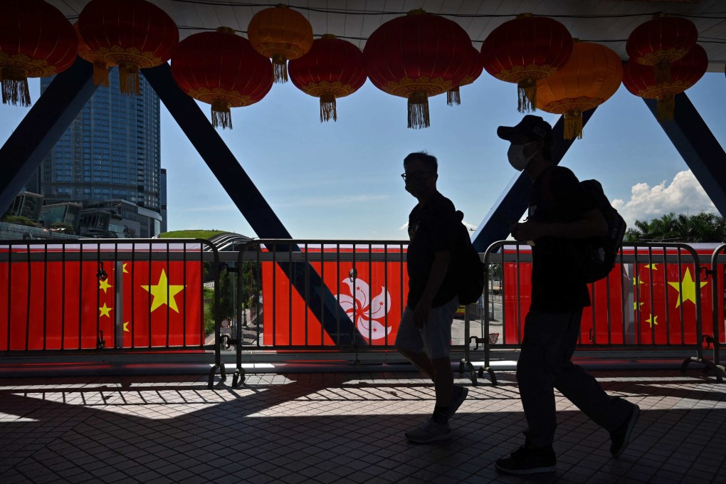 People walk past Hong Kong and China flags, hung to mark the 25th anniversary of the establishment of the Hong Kong Special Administrative Region, in Central on June 28. Photo: AFP