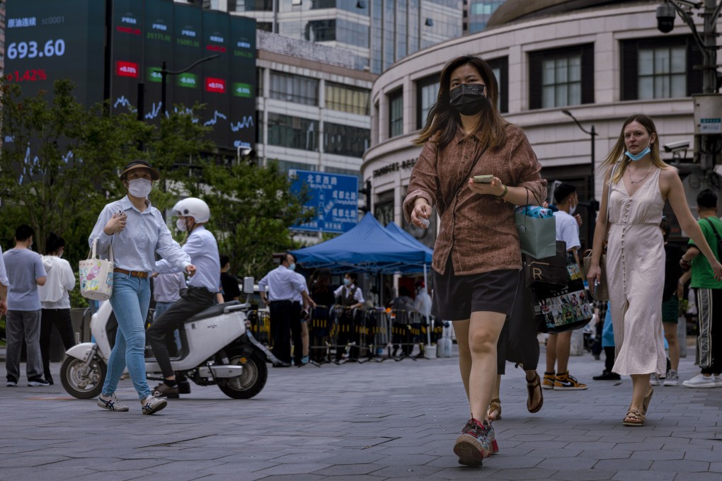 People walk past a screen showing the latest economic and stock exchange updates in Shanghai, on June 23. Photo: EPA-EFE