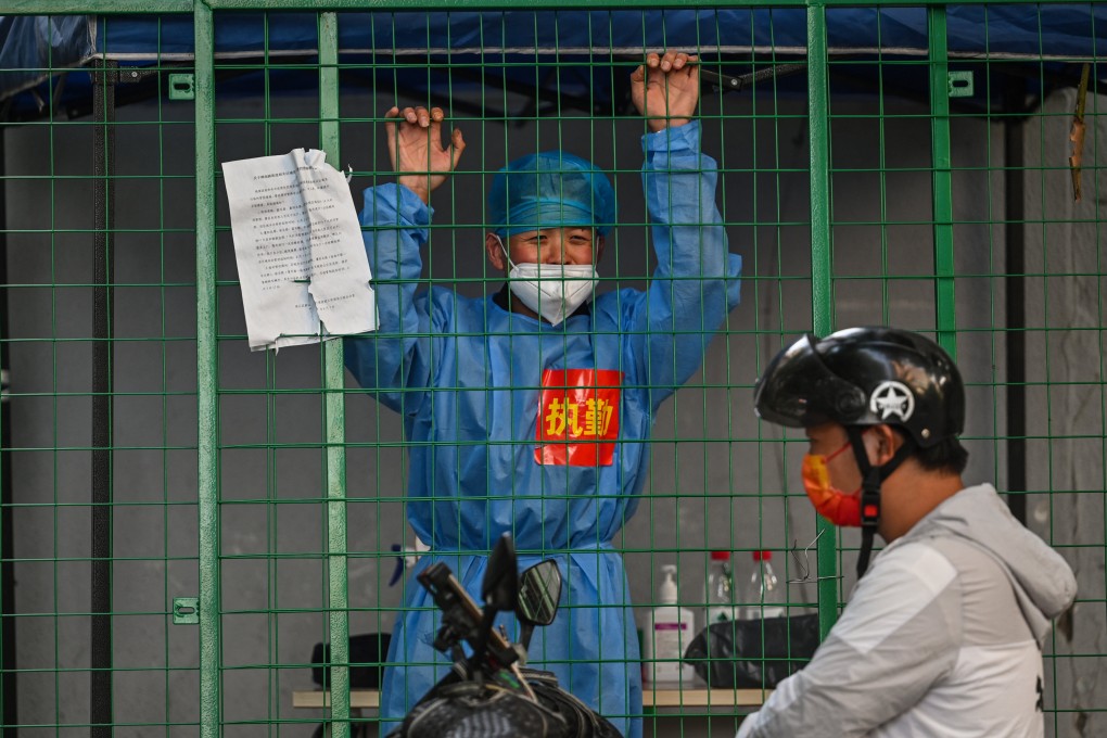 A medical worker in a residential area under Covid-19 lockdown talks with a man on a scooter in the Xuhui district of Shanghai, China, on June 16, 2022. Photo: AFP