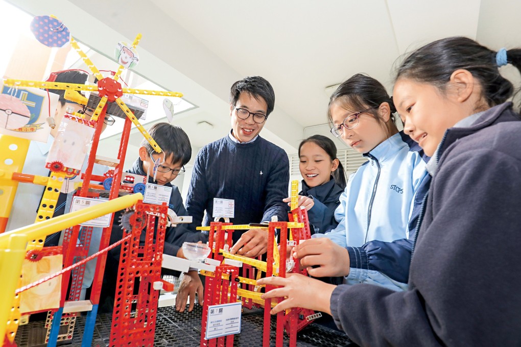 Fung Long, a CoolThink@JC Fellow and Vice-Principal at Sham Tseng Catholic Primary School, with students taking part in the education programme. Photo was taken before the pandemic. Photo: HKJC
