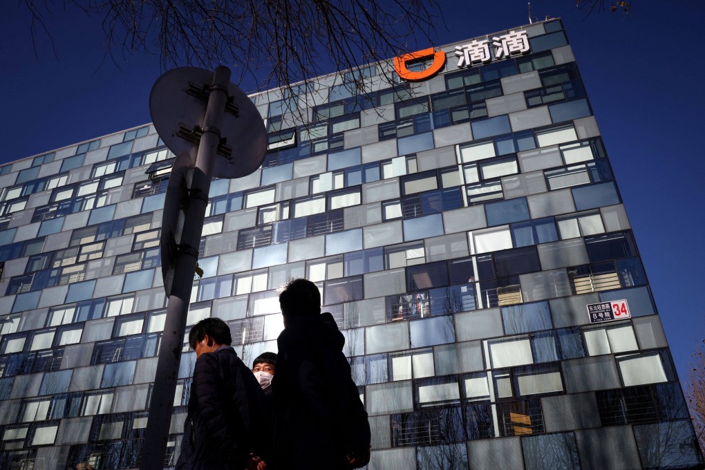 People walk past the headquarters of Chinese ride-hailing giant Didi Chuxing in Beijing. Photo: Reuters