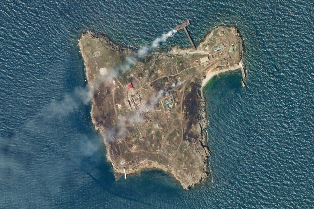 A satellite image shows smoke rising from Snake Island off the coast of Ukraine on Wednesday. Image: Planet Labs PBC via Reuters