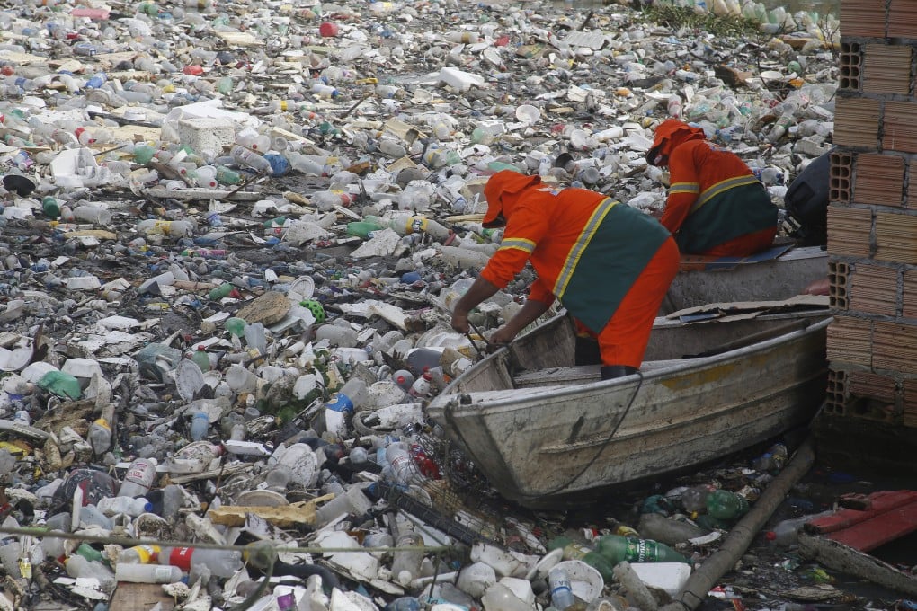 City workers remove plastics and other garbage floating on a river in Manaus, Brazil’s Amazonas state, last month. Photo: AP