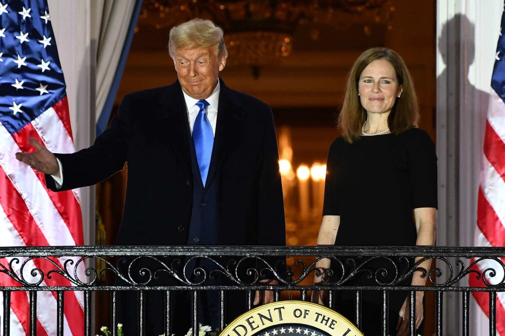 US President Donald Trump gestures next to Judge Amy Coney Barrett on a White House balcony in 2020 after she was sworn in as a member of the US Supreme Court. Photo: AFP