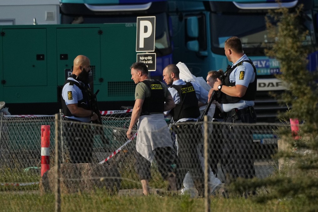 A person in a white DNA suit is taken away by police near the Field’s shopping centre after a shooting  in Copenhagen, Denmark on Sunday. Photo: Ritzau Scanpix via AP
