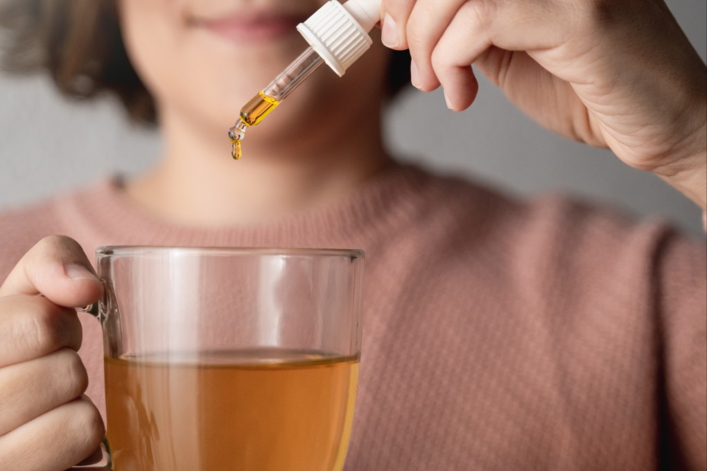 A woman adds CBD oil to tea. Hong Kong’s law enforcement authorities have proposed outlawing CBD products this year. Photo: Shutterstock