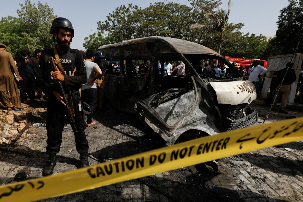 A police officer stands guard near a passenger van, cordoned after a blast at the entrance of the Confucius Institute University of Karachi, Pakistan on April 26. Photo: Reuters