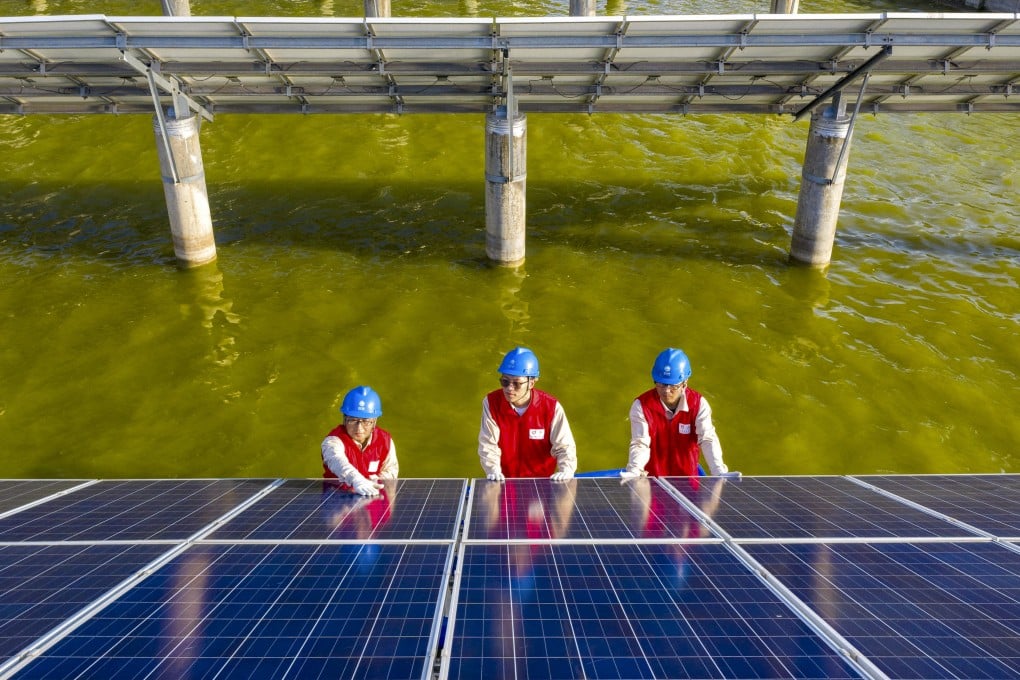 Electrical workers checking solar panels at a photovoltaic power station built in a fishpond in Haian in eastern China’s Jiangsu province. Photo: AFP