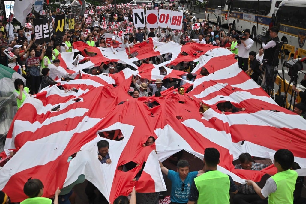 South Korean protesters tear a Japanese rising sun flag during a rally denouncing Tokyo’s wartime forced labour. File photo: AFP
