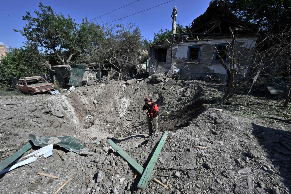 A worker stands in a crater in Kramatorsk, the day after a Russian rocket attack. Photo: AFP
