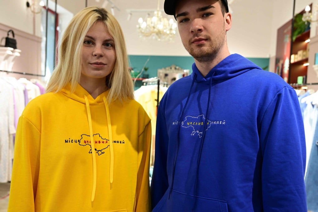 A trend for patriotic clothing in Ukraine sees slogan shirts and war designs on the rise. Ukrainian couple Anna Perebynos (left) and Vladyslav Khyzhyk wear Kolosova brand sweaters in the colours of the Ukrainian flag and the slogan “Place of Happy People”. Photo: AFP