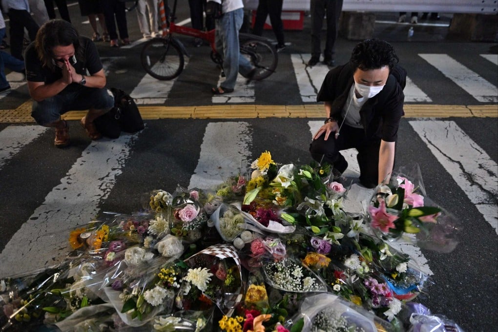 People place flowers at the scene in Nara where Shinzo Abe was shot. Photo: AFP