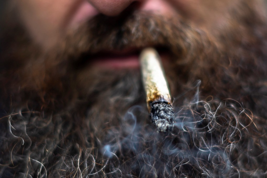 A tourist smokes a cannabis cigarette, after it was removed from the narcotics list under Thai law, in Bangkok, Thailand on June 9. Photo: Reuters