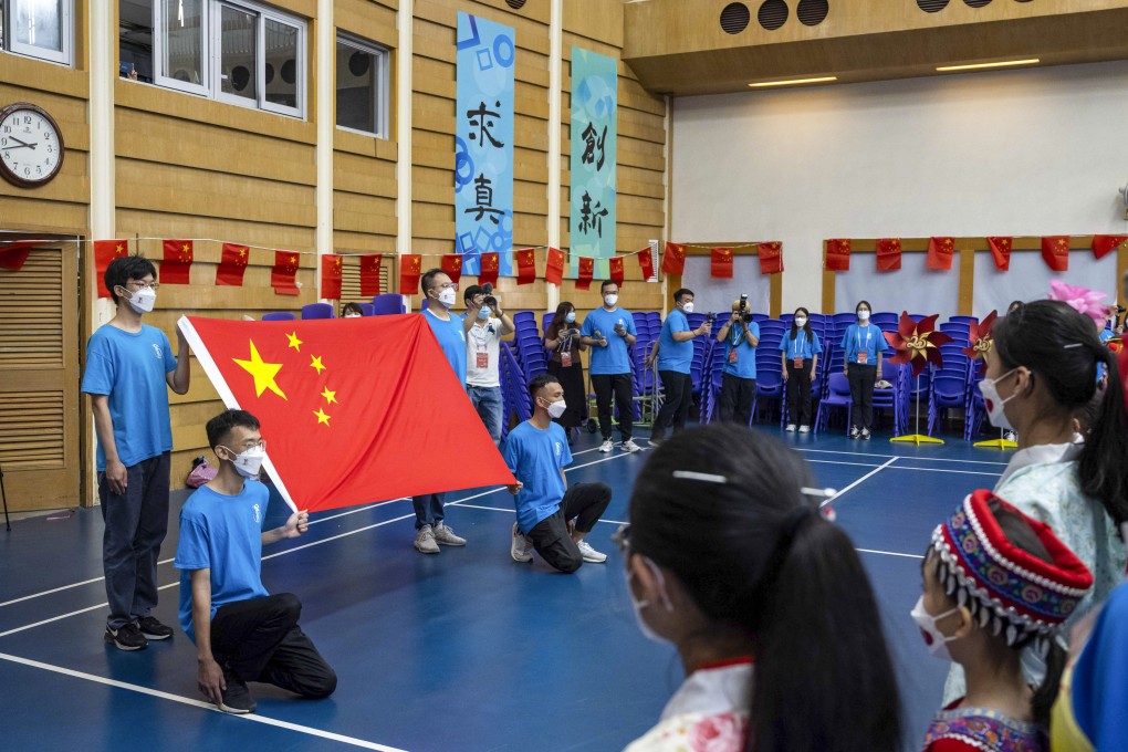 Students pose with a Chinese flag at Scientia Secondary School to celebrate the 25th anniversary of Hong Kong’s return to Chinese rule. Photo: Bloomberg