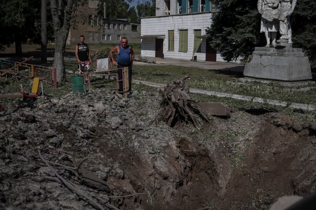 Local residents stand near a shell crater at a children playground, destroyed by Russian military strike, amid Russia’s invasion on Ukraine, in the town of Druzhkivka, in Donetsk region, Ukraine. Photo: Reuters